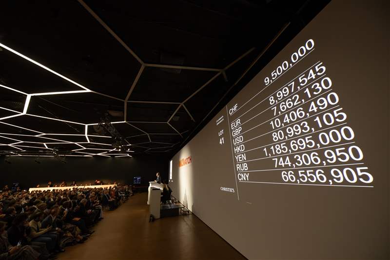 墻上的投影以不同貨幣捕捉 Only Watch 2021 的投標過程。
