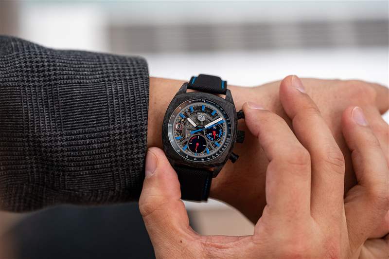 TAG Heuer Monza 鏤空表盤，佩戴在手腕上并推動手表上的按鈕。