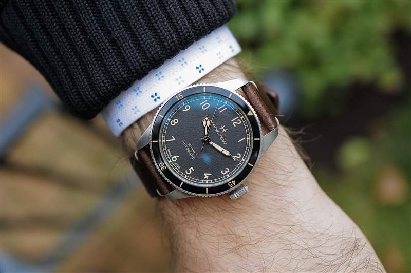 38 毫米尺寸的 Hamilton Khaki Pilot Pioneer 腕表搭配棕色皮夾克。